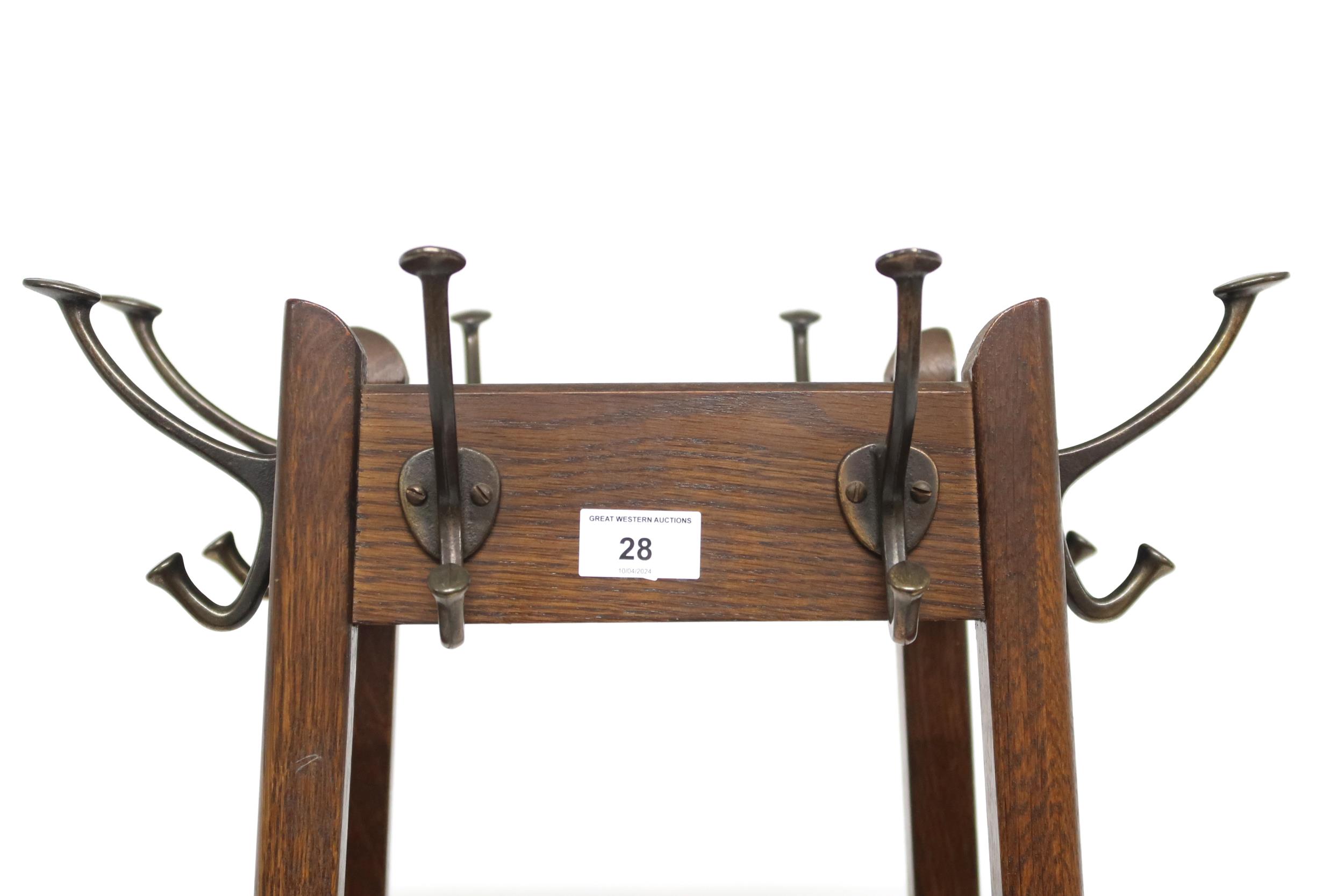 An early 20th century oak freestanding hat and coat stand with stylized metallic hooks to each side, - Image 2 of 3