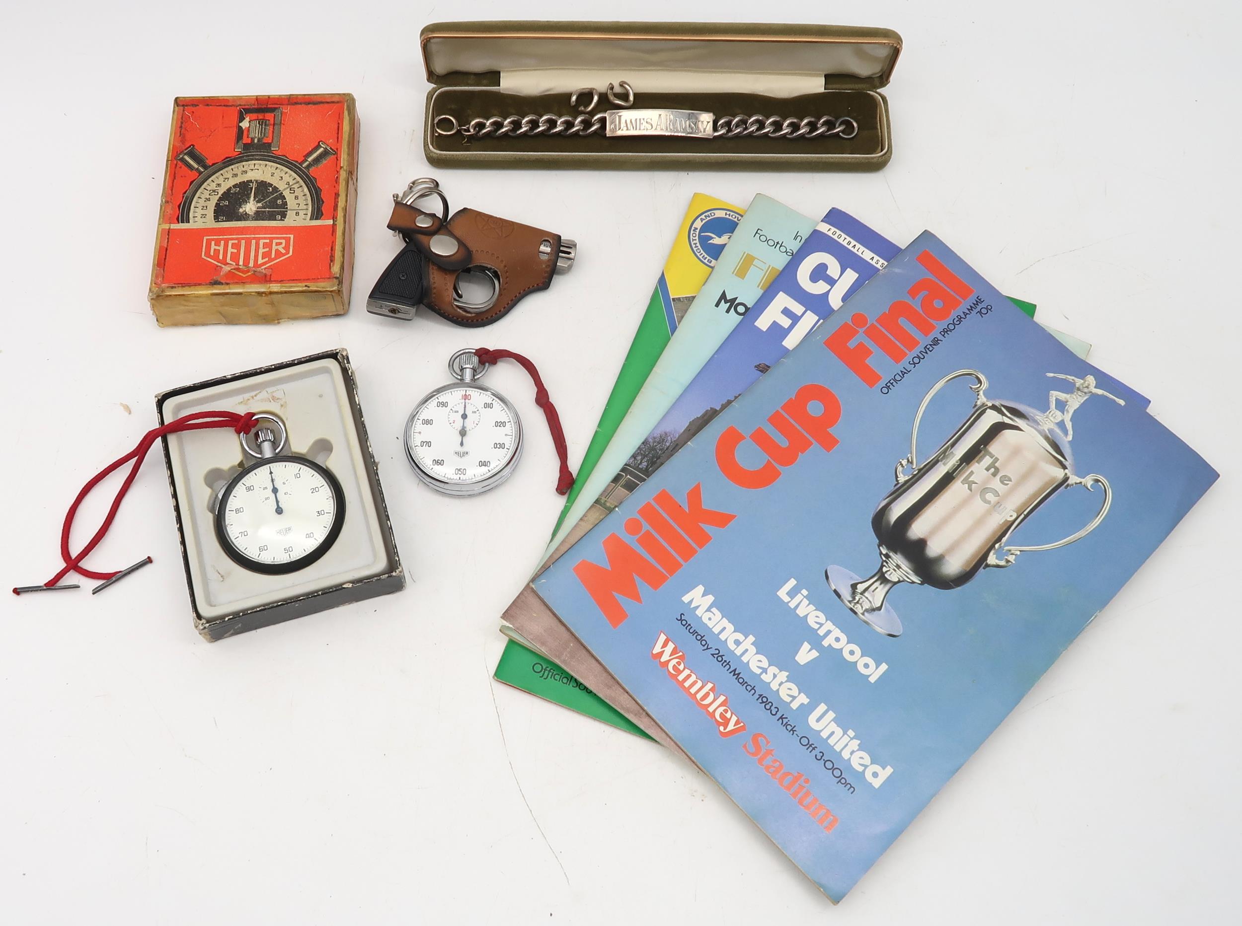 A London silver ID bracelet, two stopwatches by Heuer, four various football programmes and a pistol
