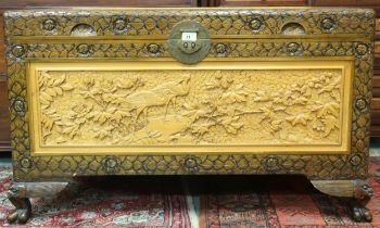 A 20th century Chinese camphor wood blanket chest with inset white oak panels carved with nature