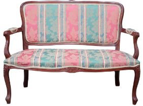 A 20th century mahogany framed two seater parlour settee with striped floral upholstery on carved