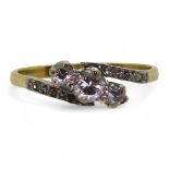 An 18ct vintage three stone ring the shoulders set with diamond accents, the three main diamonds are