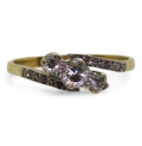 An 18ct vintage three stone ring the shoulders set with diamond accents, the three main diamonds are