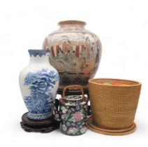 A Chinese jar on stand, a blue and white vase on stand and a teapot within in wicker case