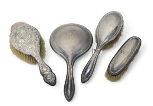 A three piece silver dressing set, Birmingham 1904, and and another silver brush, by James & William