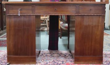 An early 20th century mahogany pedestal desk with central long drawer flanked by short drawers