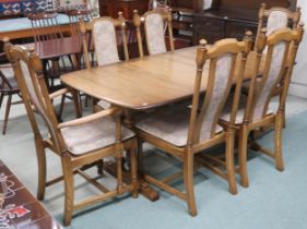 A 20th century Ercol elm and beech extending dining table and six chairs, table on trestle