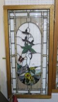 A large stained and leaded glass panel depicting a heron and flowers, in a wooden frame, 61cm x
