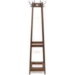 An early 20th century oak freestanding hat and coat stand with stylized metallic hooks to each side,