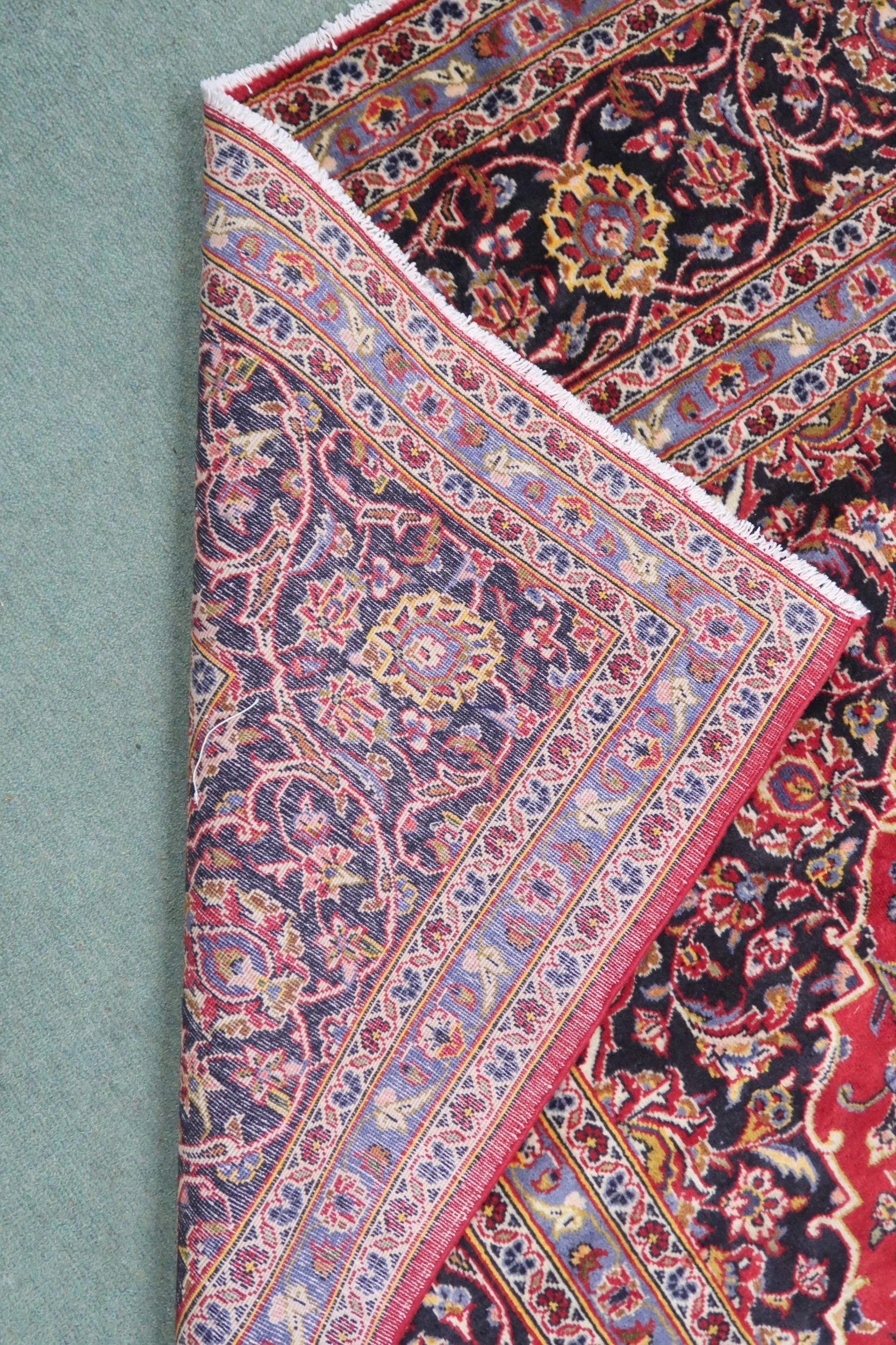 A RED GROUND KASHAN RUG  With dark blue and cream diamond central medallion and matching spandrels - Image 7 of 9