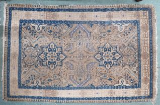 A beige ground Malayer rug with two blue medallions on geometric patterned ground within multiple