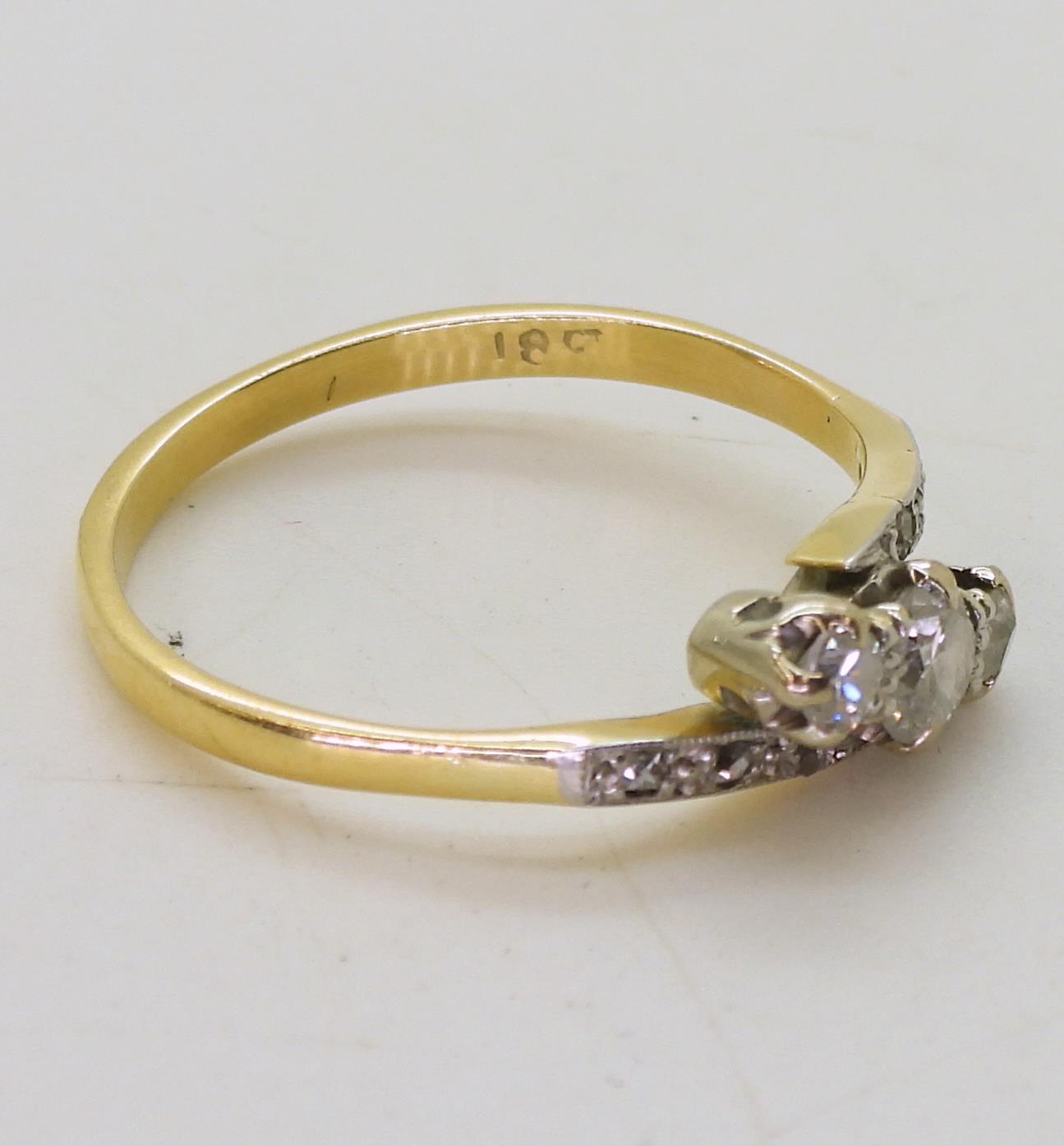 An 18ct vintage three stone ring the shoulders set with diamond accents, the three main diamonds are - Image 2 of 2