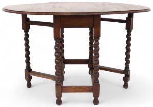 A late Victorian oak drop leaf table on barley twist supports joined by stretchers, 73cm high x 91cm