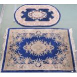 A lot of two assorted blue ground Oriental style rugs with floral central medallions and borders,