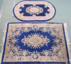 A lot of two assorted blue ground Oriental style rugs with floral central medallions and borders,