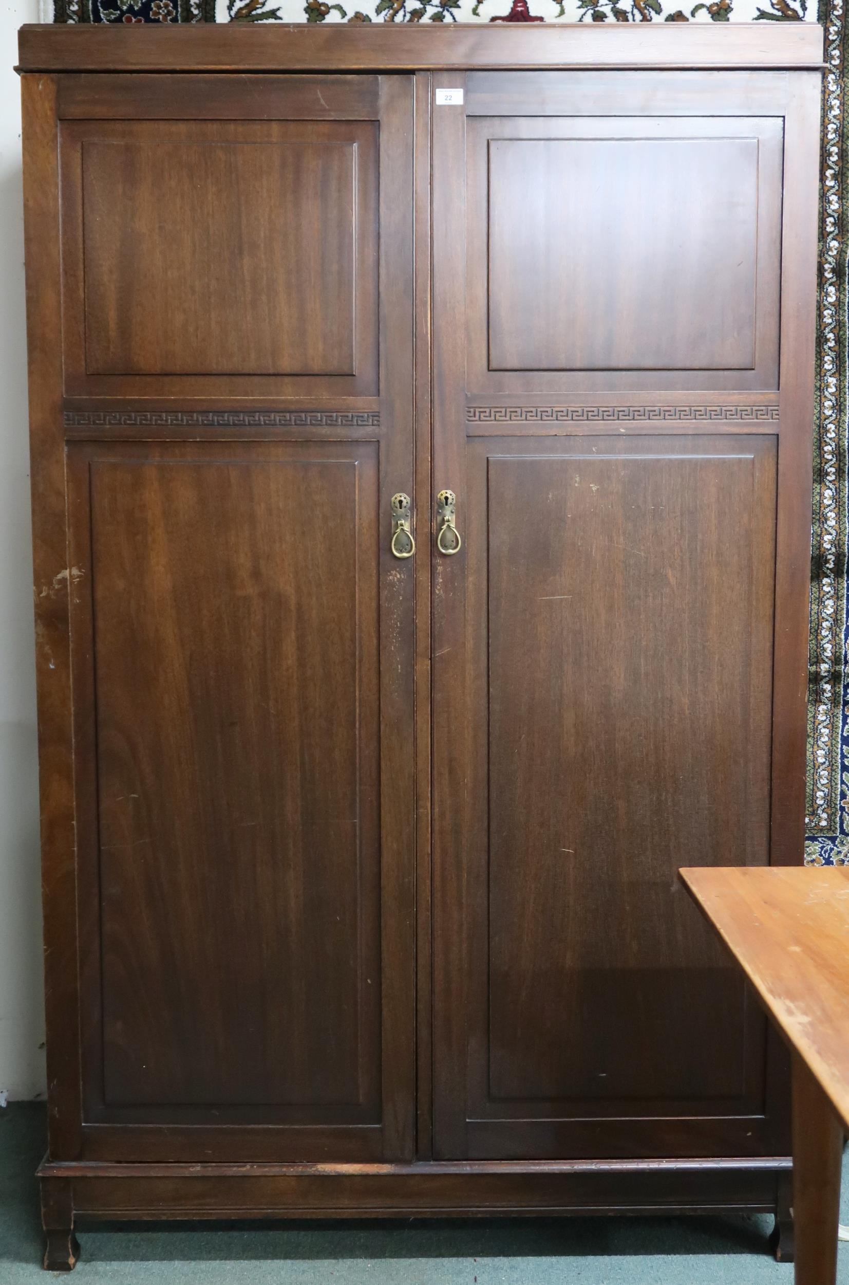 An early 20th century mahogany compactum wardrobe with pair of doors carved with Grecian key