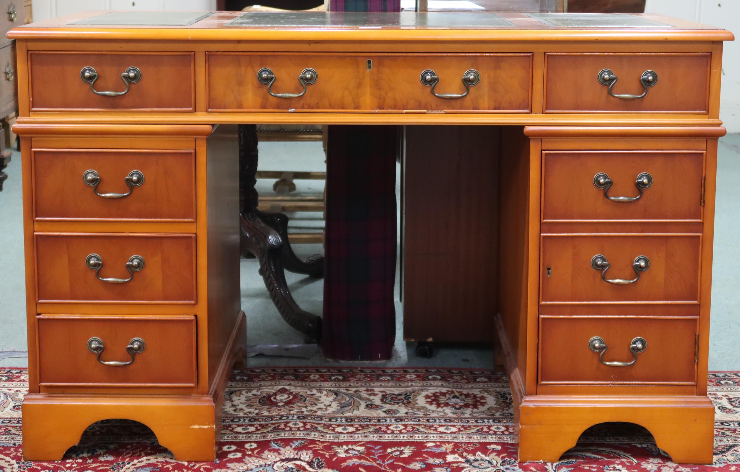 A 20th century pedestal desk with green leather skiver over central drawer flanked by four drawer