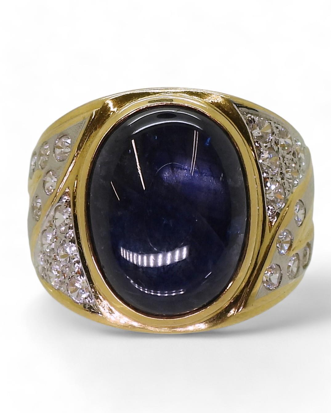 A yellow metal ring set with a star sapphire and clear gems, size S, weight 13.7gms Condition