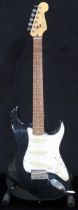 A Fender Stratocaster in black and white scratch plate with a gig bag. This Instrument is from the