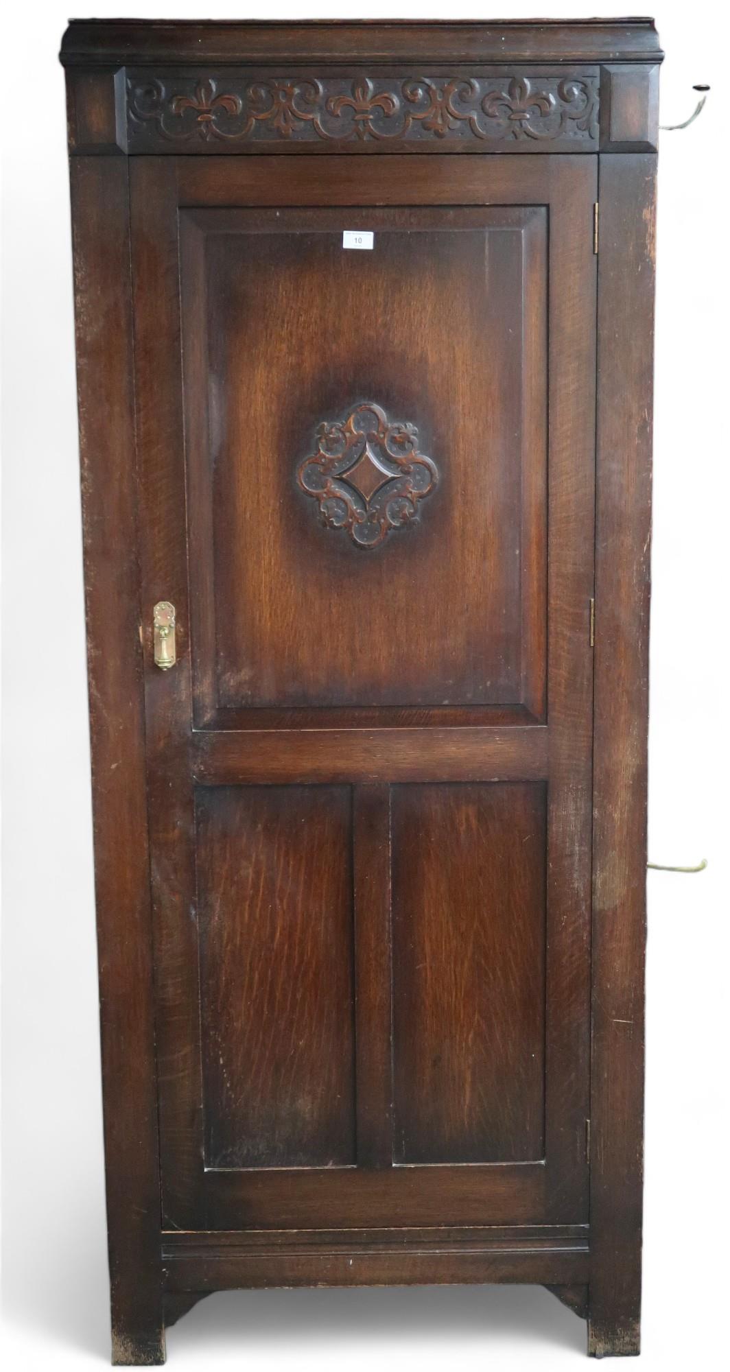 A 20th century oak single door hall robe with single panelled door flanked by sides mounted with