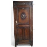 A 20th century oak single door hall robe with single panelled door flanked by sides mounted with