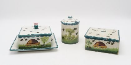 A Wemyss ware honey box and cover with stand, another honey box and cover and a cylindrical honey
