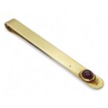 A yellow metal tie slide set with a cabochon ruby weight 11.2gms Condition Report:Available upon