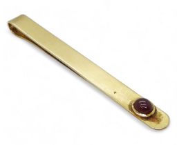 A yellow metal tie slide set with a cabochon ruby weight 11.2gms Condition Report:Available upon
