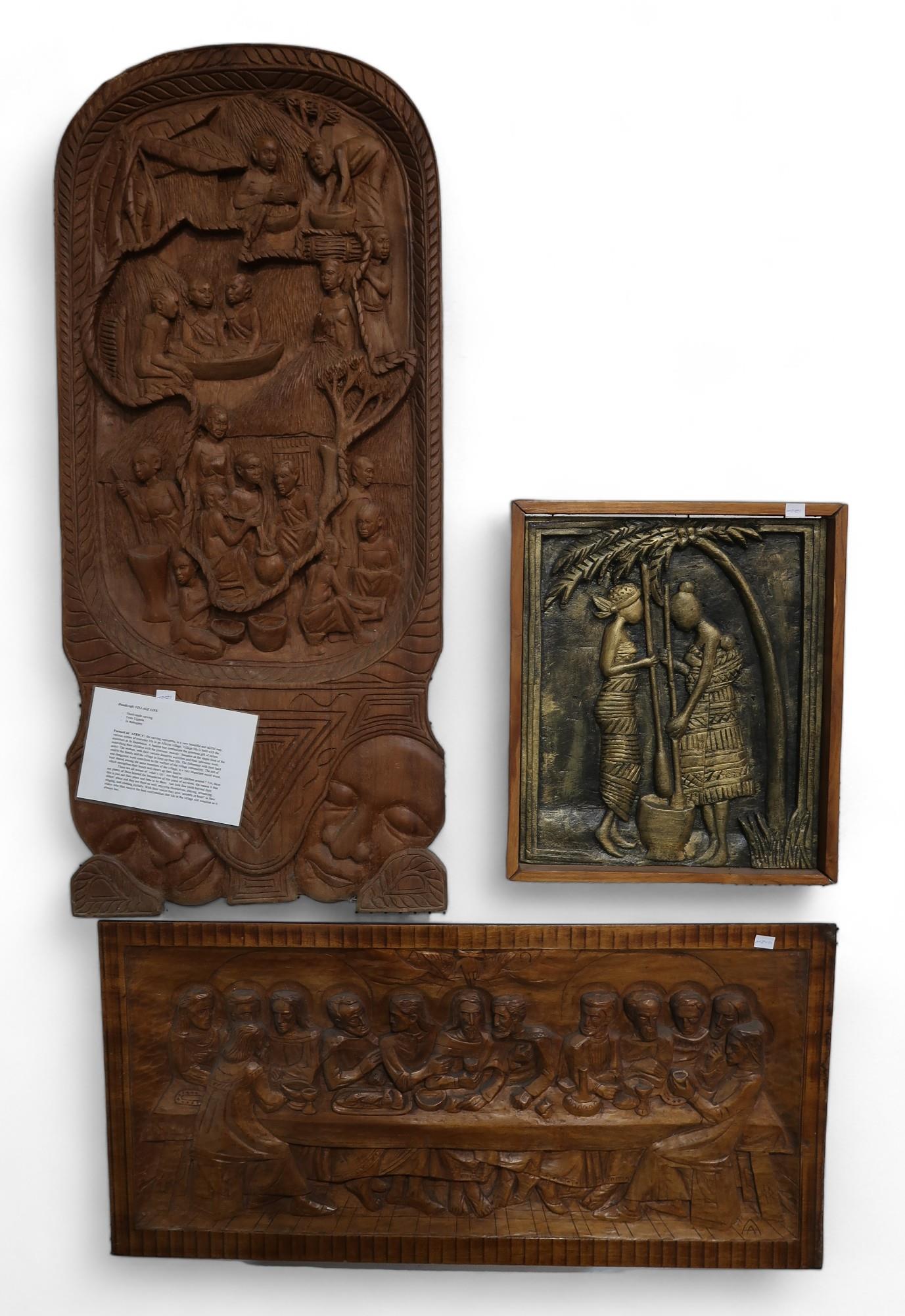 A Ugandan carved mahogany panel depicting village life, together with a gilded carved panel of