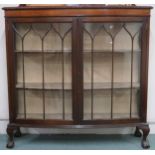 An early 20th century mahogany bow fronted display cabinet with pair of glazed beaded doors on