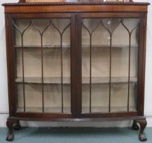 An early 20th century mahogany bow fronted display cabinet with pair of glazed beaded doors on