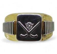 A yellow and white metal signet ring with a hockey theme and set with a diamond accent, finger
