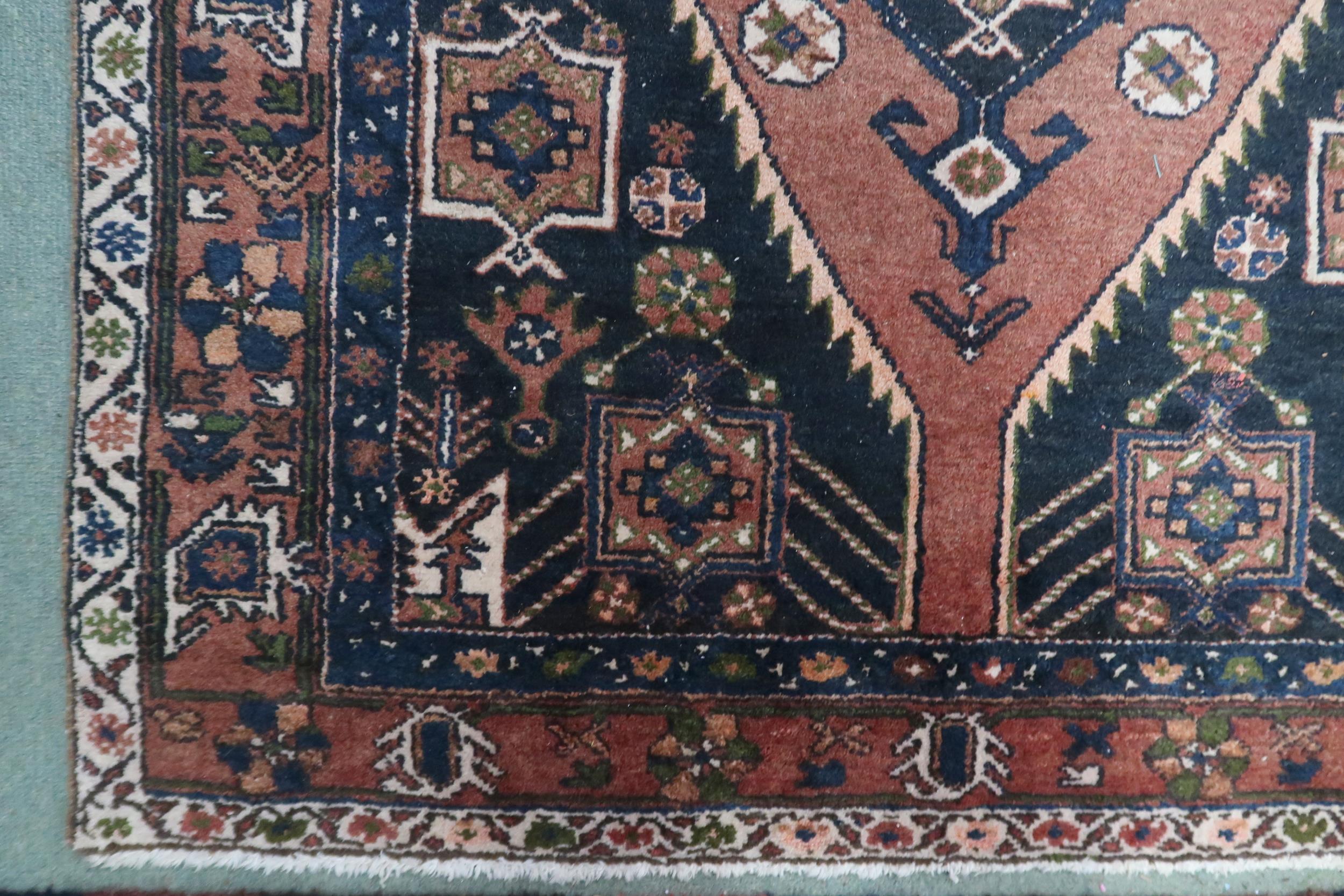 A pink ground balouchi rug with blue diamond central medallion, matching spandrels and pink - Image 2 of 3