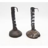 A pair of 17th/18th century iron "pig tail" candlesticks, set upon fruitwood bases, each measuring
