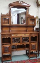 A late Victorian mahogany mirrored back display cabinet with architectural surmount over central