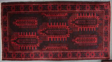 A dark red ground Afghan Bellucci tribal rug with geometric patterned ground within geometric
