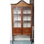 An Edwardian mahogany and satinwood inlaid display cabinet with arched moulded cornice over pair