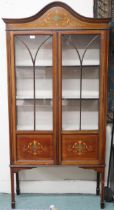 An Edwardian mahogany and satinwood inlaid display cabinet with arched moulded cornice over pair