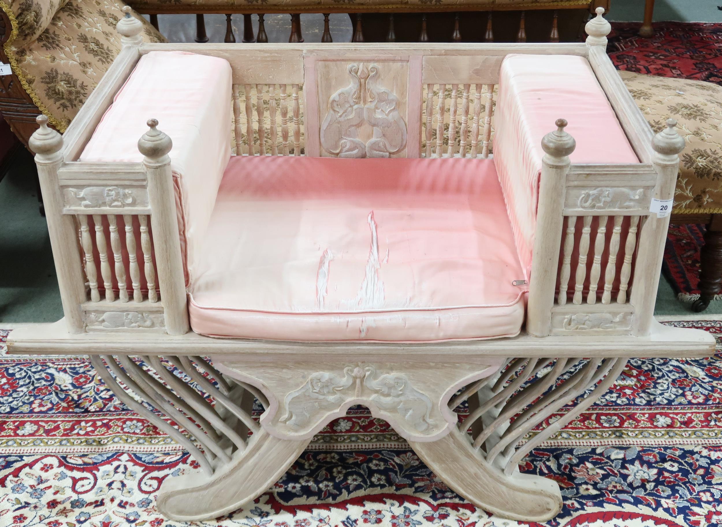 A 20th century lime washed elephant "Howdah" saddle chair with square bolster cushions within spinel