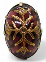 A yellow metal ring set with an earlier garnet carbuncle with inset gold foliage with rose cut