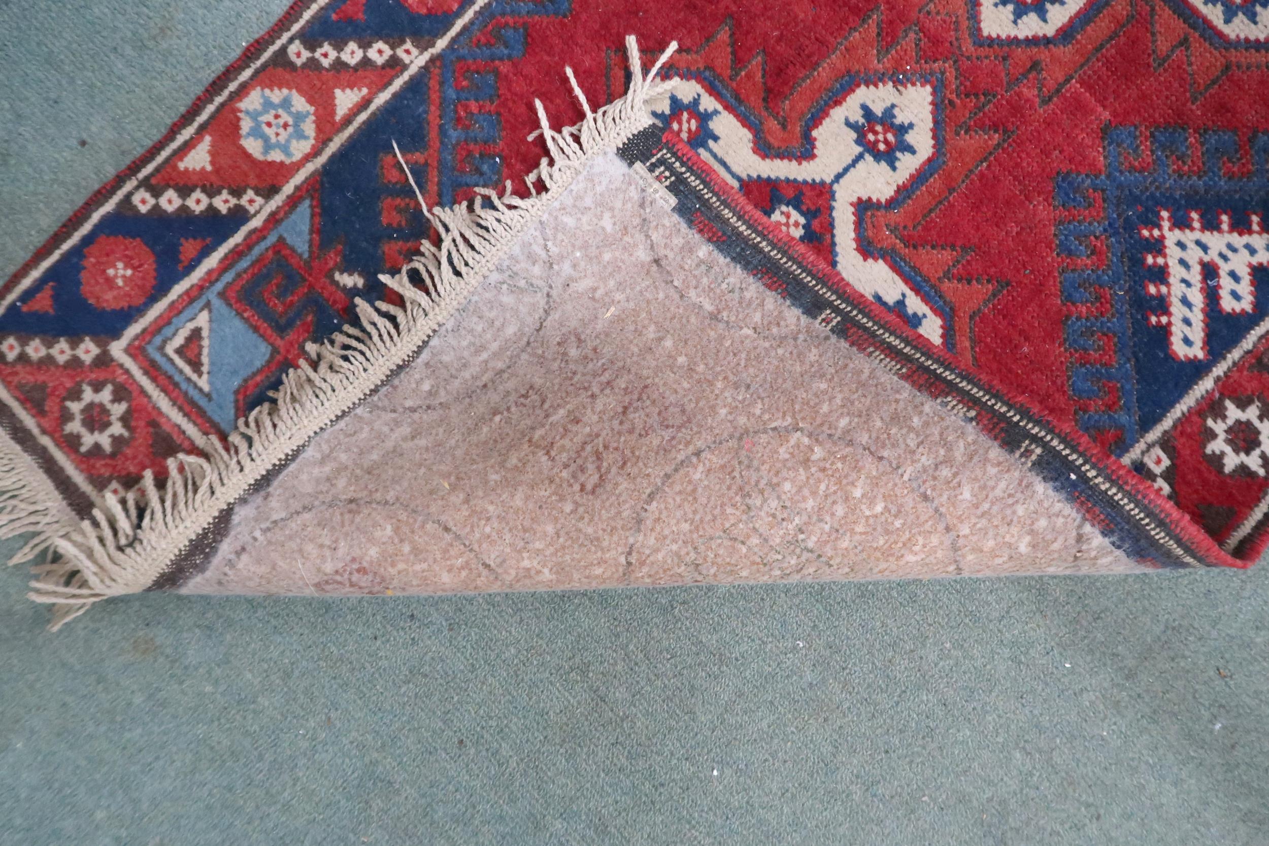 A red ground Shiraz runner with seven cruciform medallions, dark blue spandrels within multicoloured - Image 3 of 3