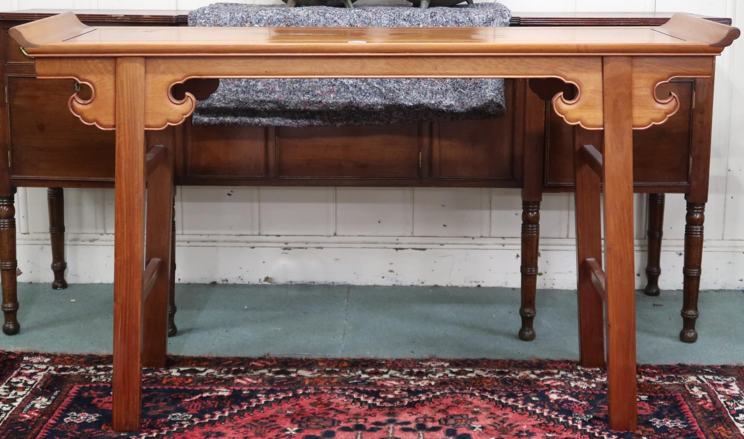 A contemporary Oriental hardwood altar table with upswept rectangular top with shaped friezes on