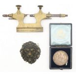A brass and steel miniature lathe, together with a cast brass lion mask mount/applique and a cased