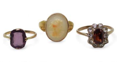 A 9ct gold cameo ring, size N, a 9ct purple glass ring, size J1/2, and a yellow metal garnet and