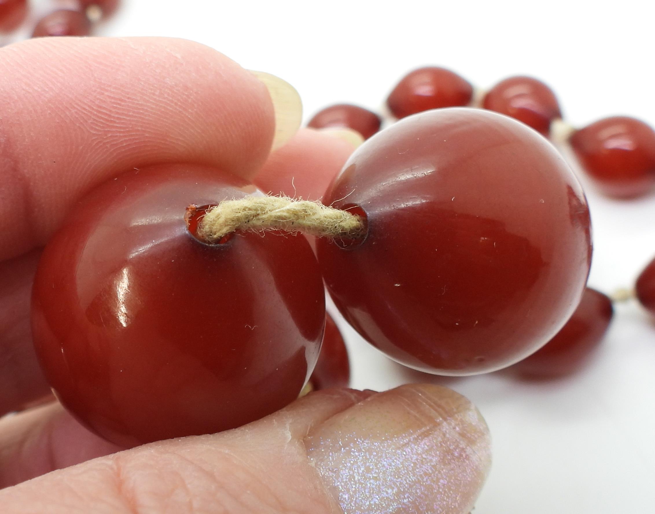 Two strings of cherry amber coloured beads, weight 158.1gms Condition Report:No condition report - Image 2 of 8