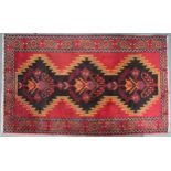 A red and black geometric ground Persian Village rug with geometric floral/foliate design with