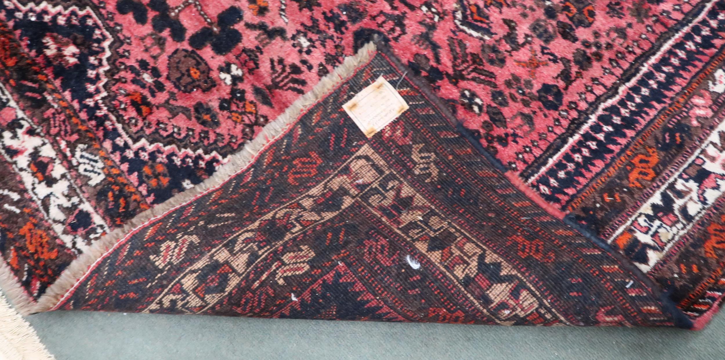 A red ground Hamadan rug with three diamond form medallions and dark blue spandrels within - Image 3 of 4