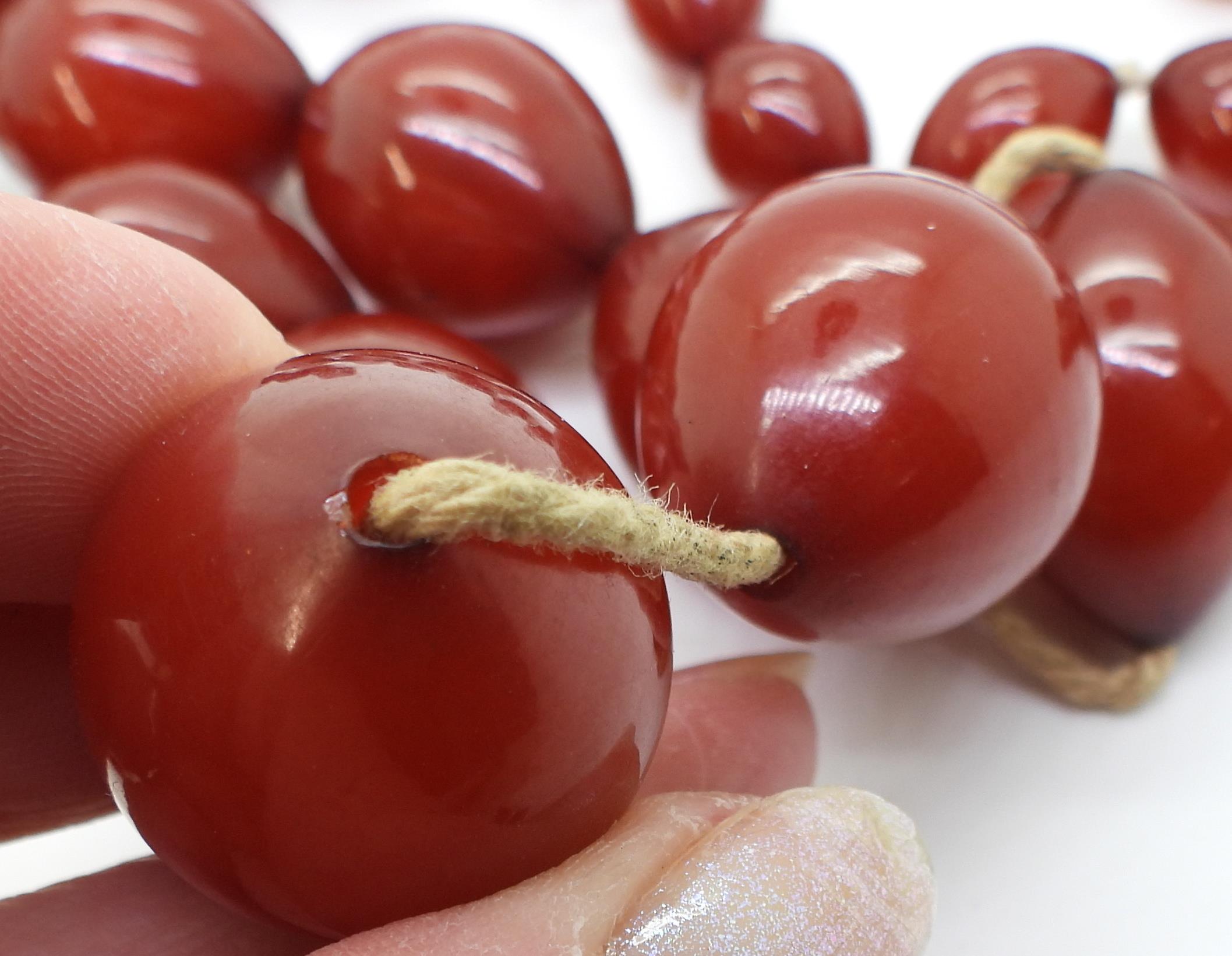 Two strings of cherry amber coloured beads, weight 158.1gms Condition Report:No condition report - Image 3 of 8