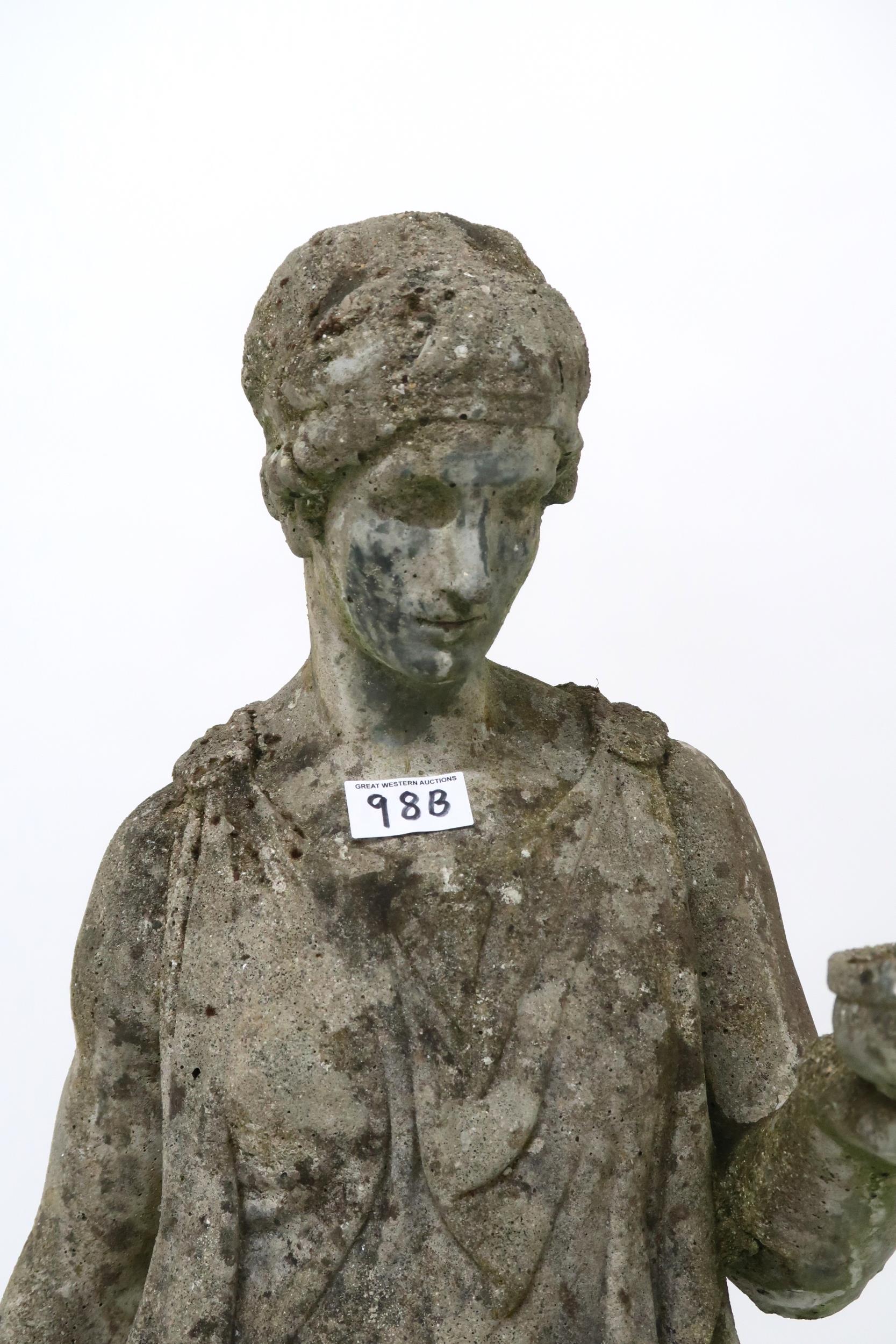 A 20th century reconstituted stone garden statue of a classical lady in toga carrying jug and - Image 2 of 3