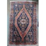 A pink ground balouchi rug with blue diamond central medallion, matching spandrels and pink