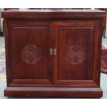 A 20th century Oriental hardwood bar/drinks cabinet with folding counter top over pair of cabinet